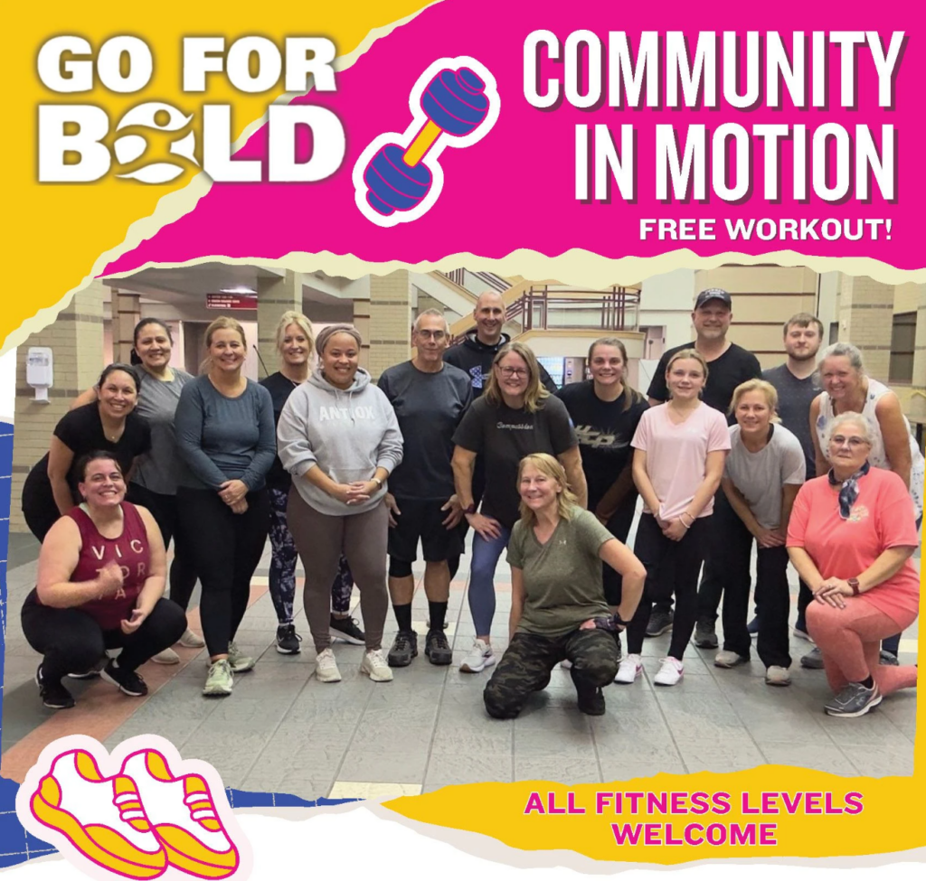 A group of people of various ages pose and smile in a gym. The promotional text says, "Go for Bold. Community in Motion. Free workout! All fitness levels welcome." Graphics feature sneakers and a dumbbell.
